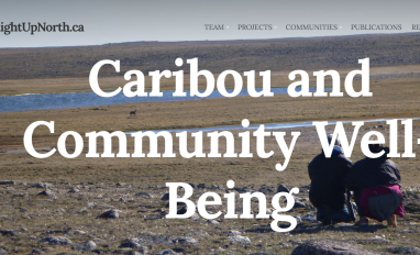Image of tundra with two people crouched down, facing away from the camera towards a herd of caribou in the distance